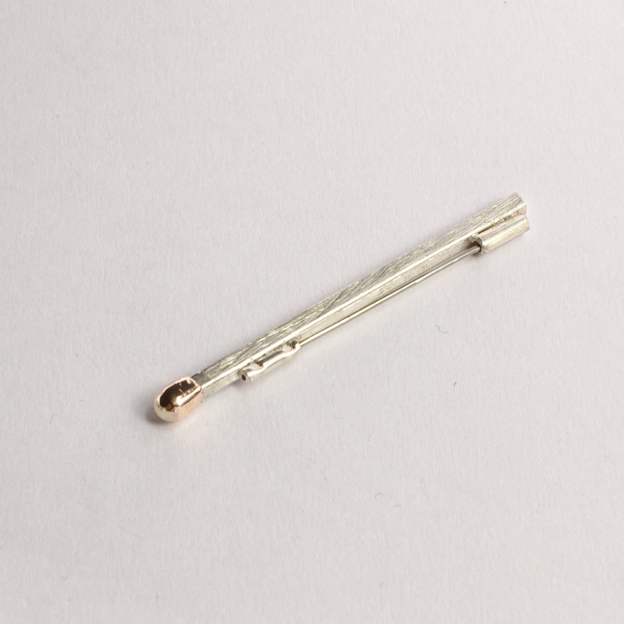 DM821B: Live matchstick brooch