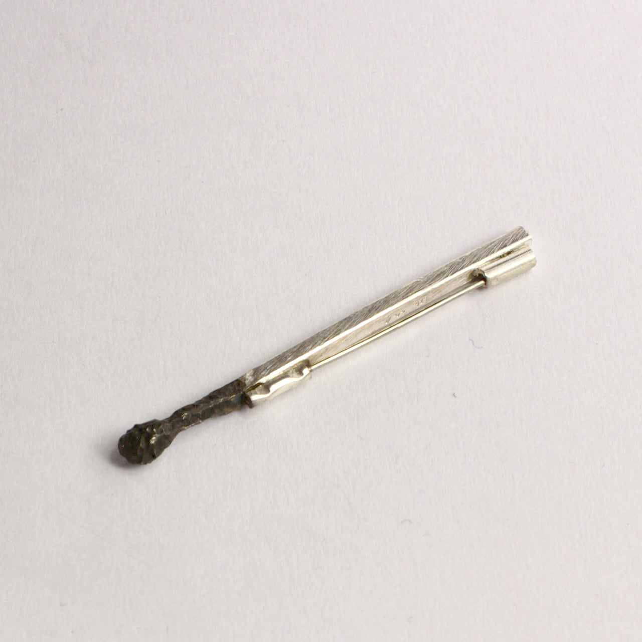 DM822B: Burnt matchstick brooch